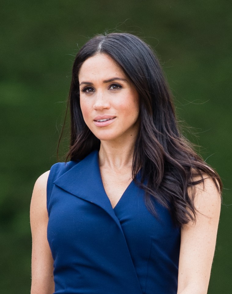 a woman in a blue dress stands in front of a green background