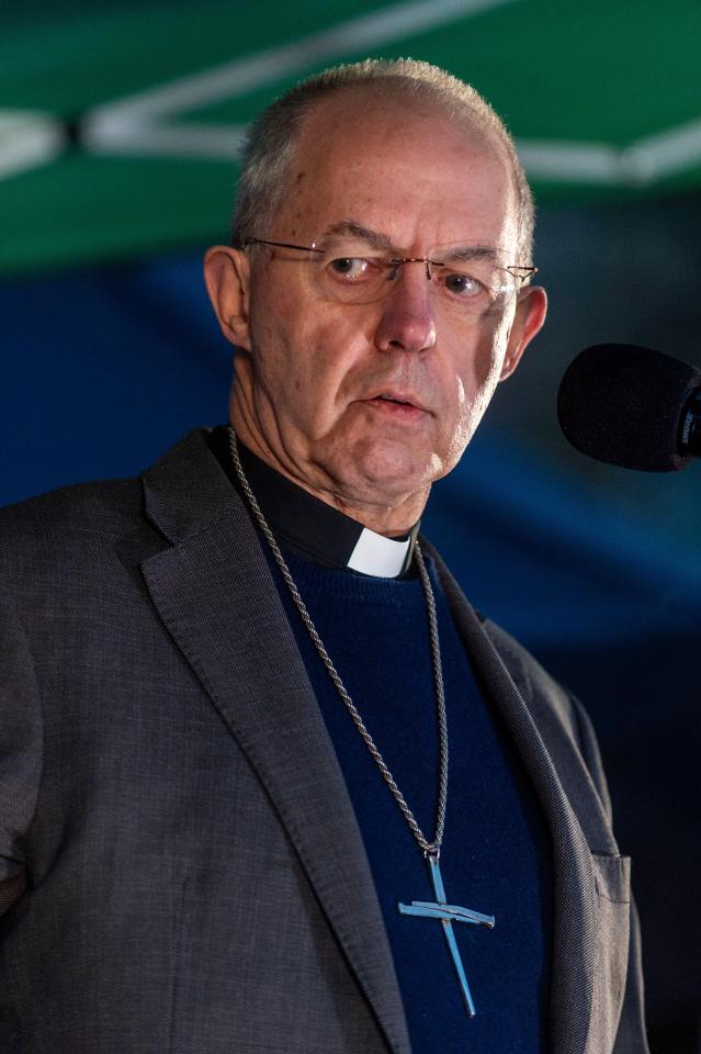 a man in a suit has a cross necklace around his neck