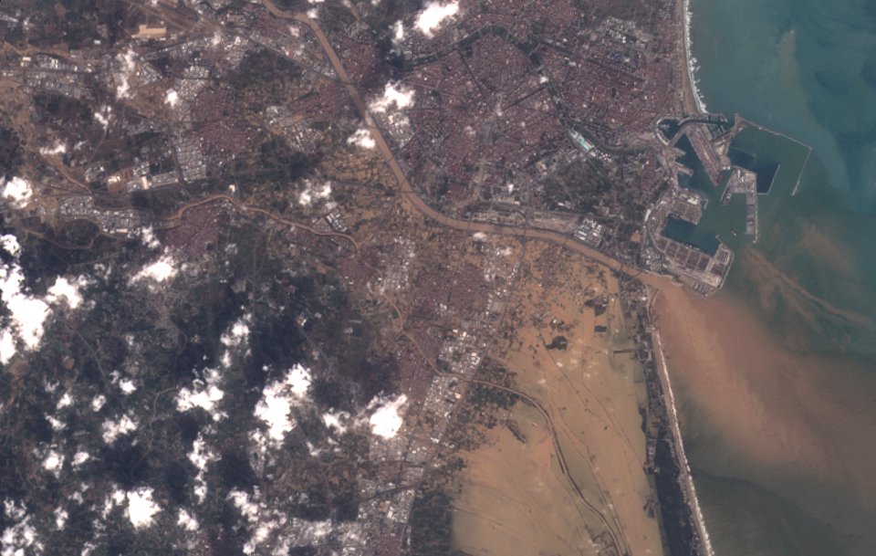 an aerial view of a city surrounded by water and clouds