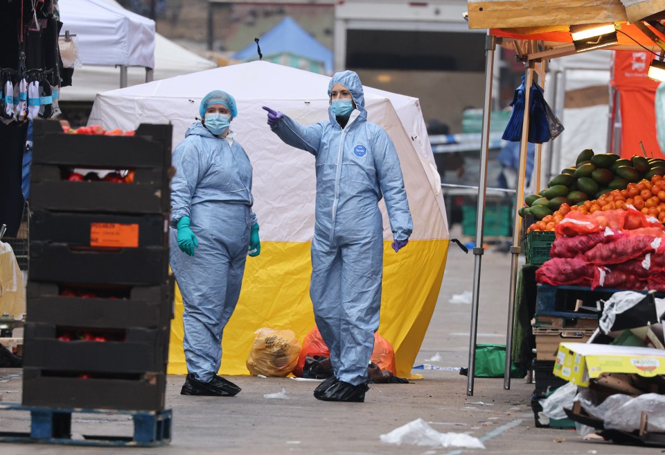 two people in protective suits standing in front of a tent that says dynex