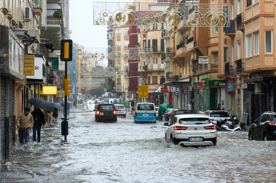cars are driving down a flooded street under a sign that says dubano