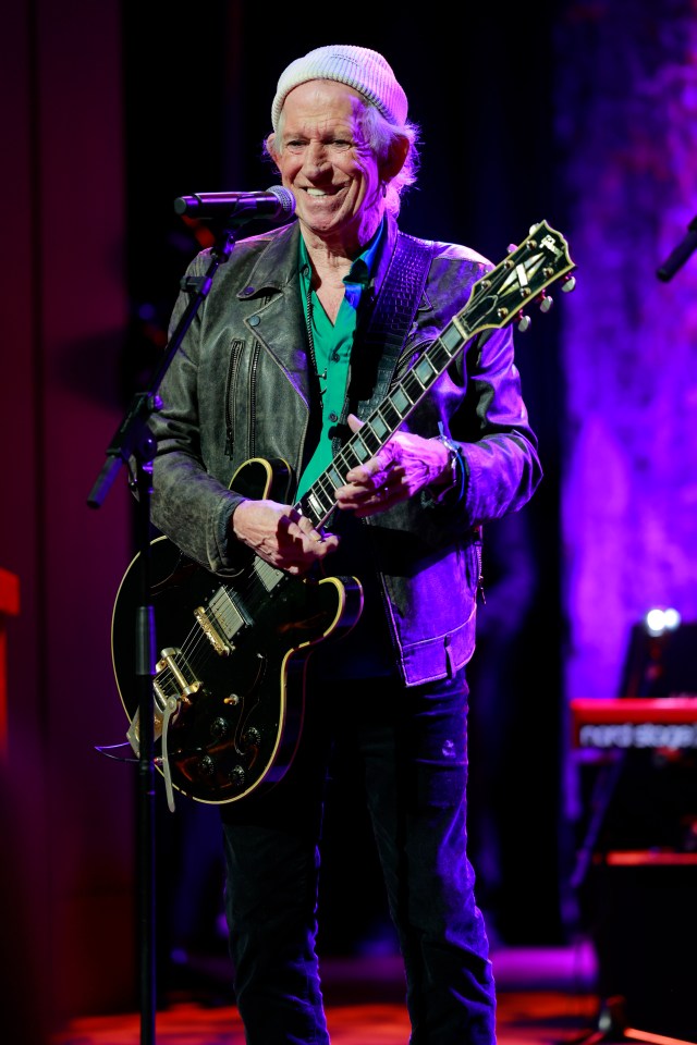 a man playing a guitar and singing into a microphone