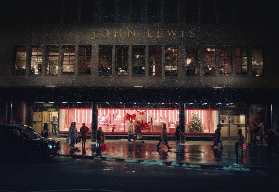 people are walking in front of a john lewis store