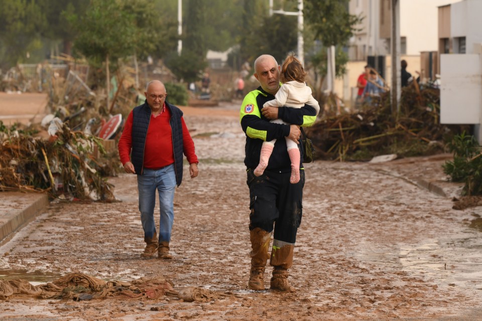 a man carrying a child has a patch on his uniform that says ' a ' on it