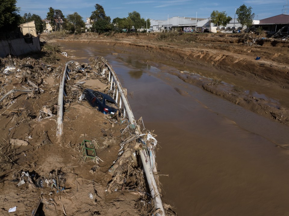 a car is stuck in the mud near a bridge