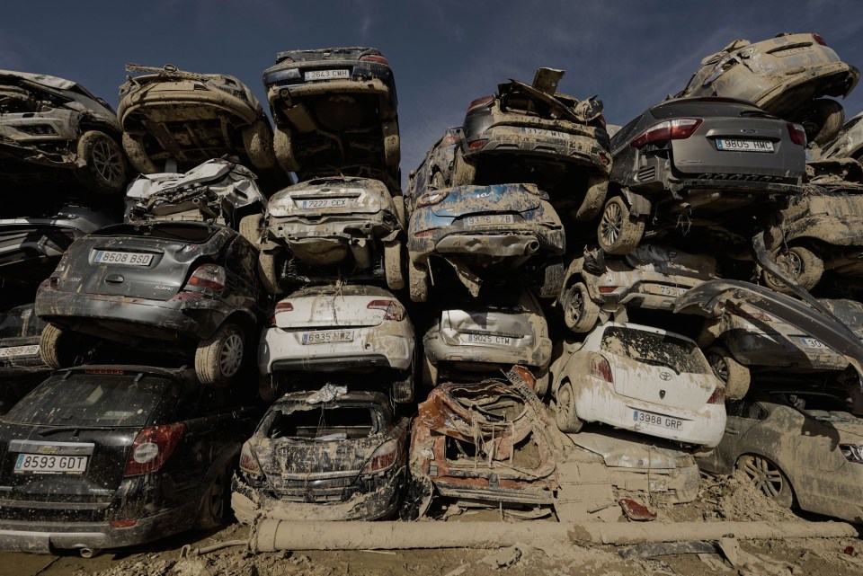 a bunch of cars are stacked on top of each other one of which has a license plate that starts with the letter b