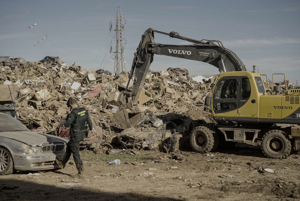 a volvo excavator is digging in a pile of trash