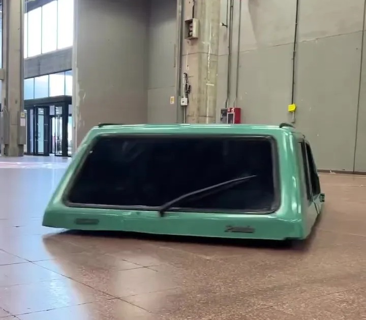 a green canopy is sitting on the floor in an empty building