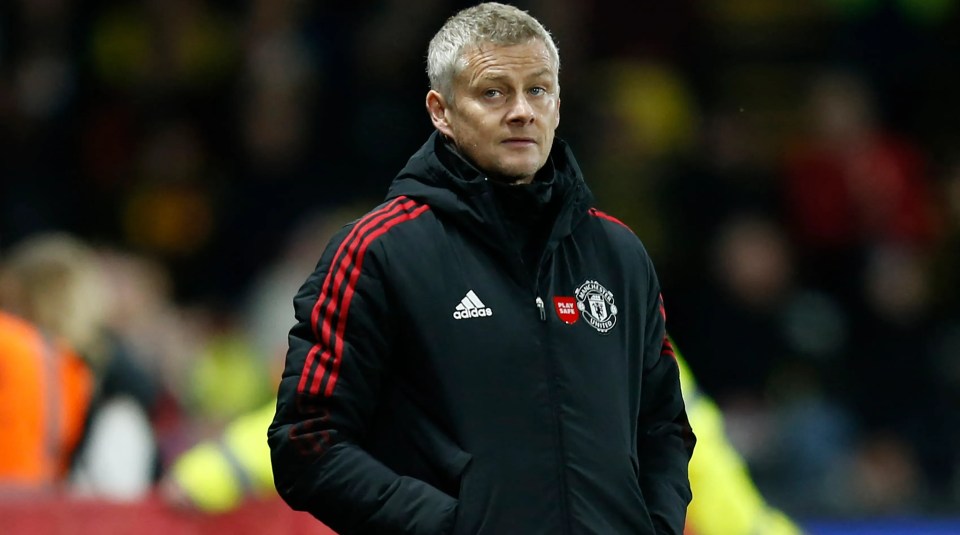 a man wearing an adidas jacket stands in front of a crowd