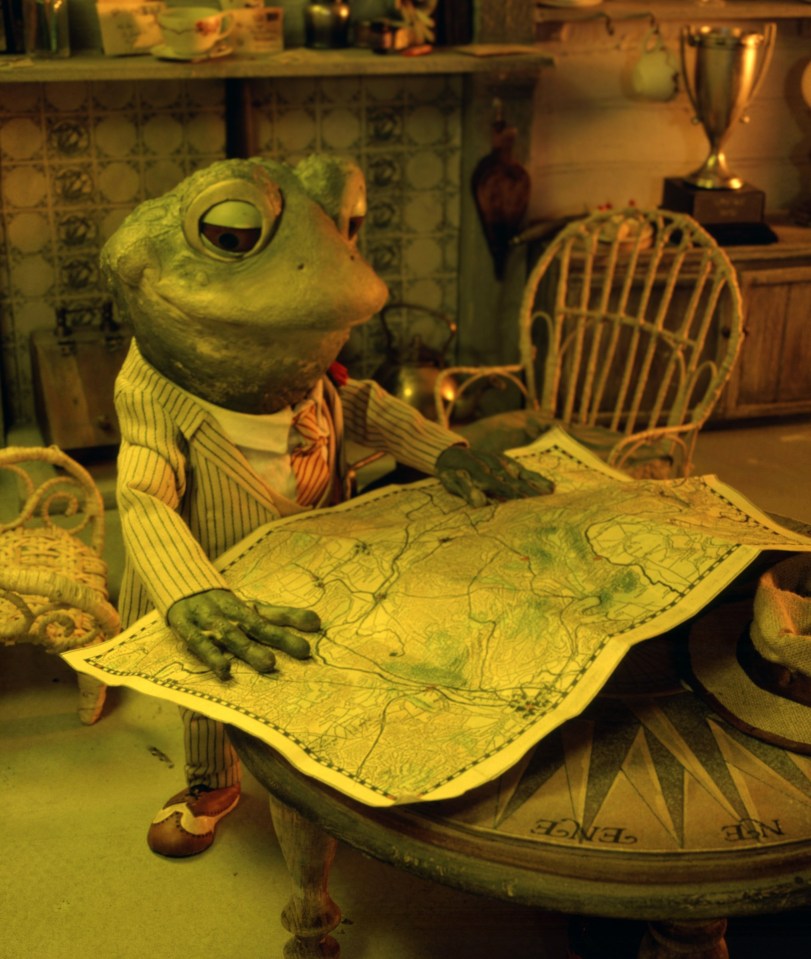 a frog in a suit is looking at a map