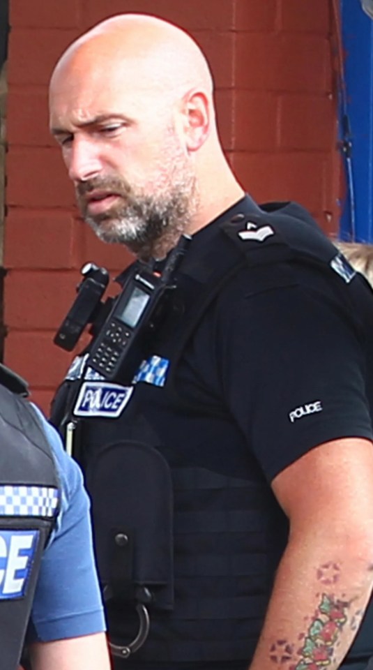 a man in a police uniform has a tattoo on his arm