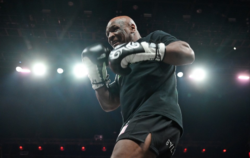 a man wearing boxing gloves and shorts with the word tyson on them
