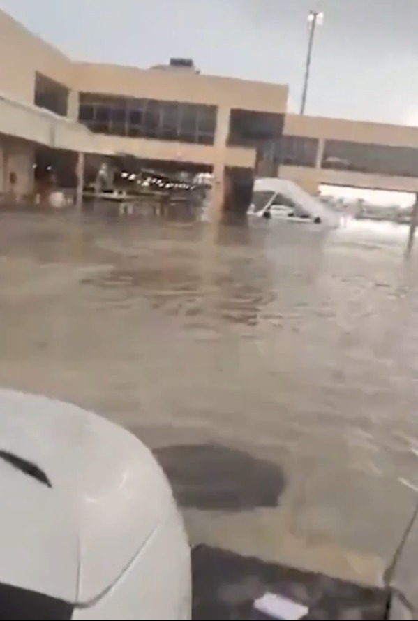 a flooded parking lot with a building in the background