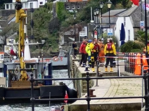 a group of people are standing on a dock near a boat with the number 15 on it