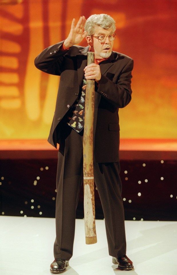 a man in a suit and tie is holding a long stick