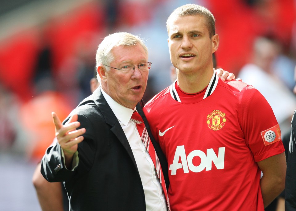 a man wearing a red aon jersey talks to another man