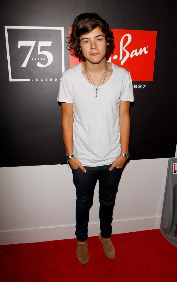 a young man stands in front of a ray ban sign