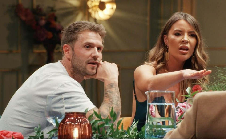 a man and a woman sit at a table with a pitcher of water