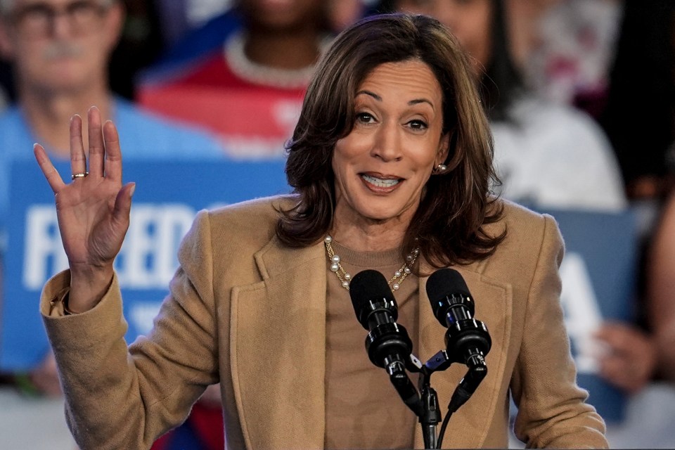 a woman speaking into a microphone with a sign behind her that says feed