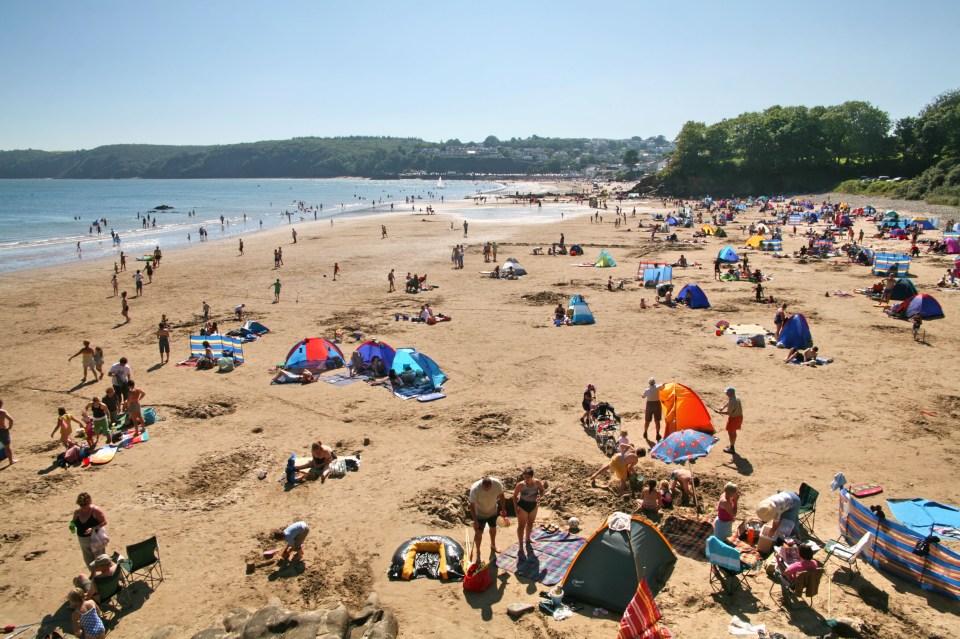 a beach filled with people and tents on a sunny day
