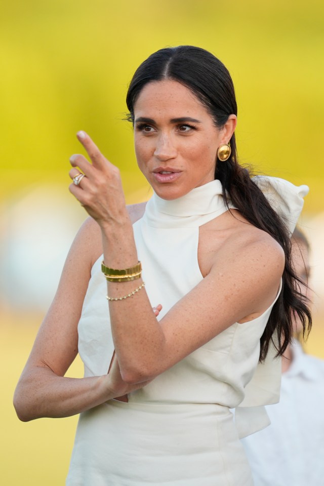a woman wearing a white dress and gold earrings