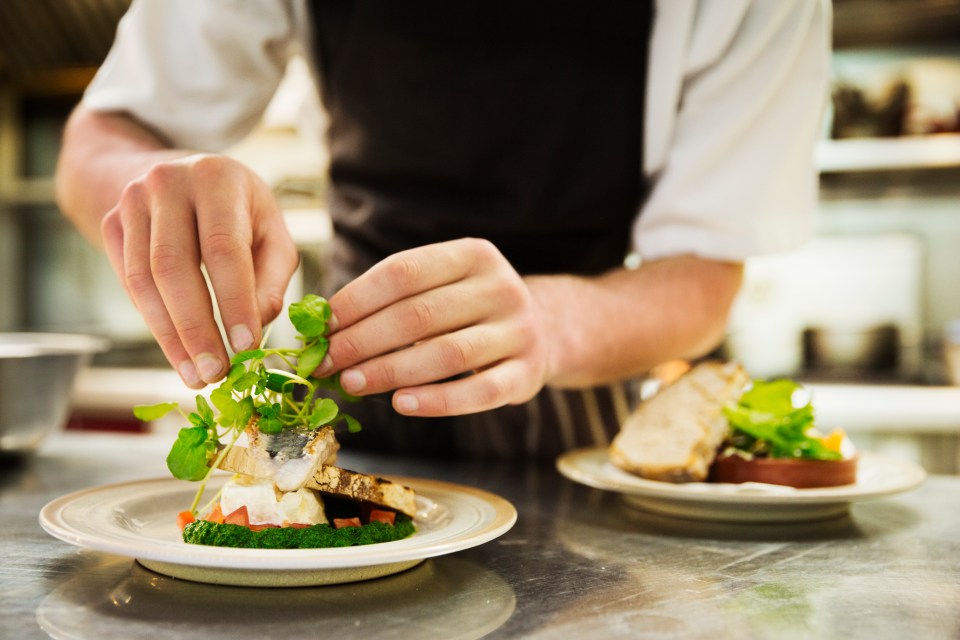 a chef prepares a plate of food in a kitchen