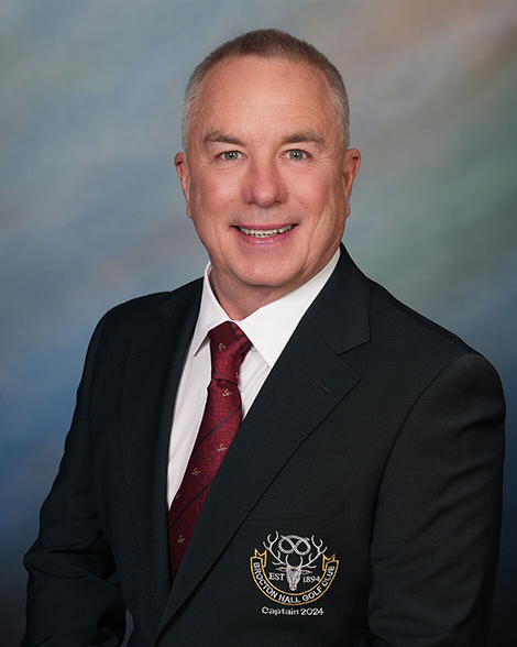 a man in a suit has a patch on his jacket that says captain 2024