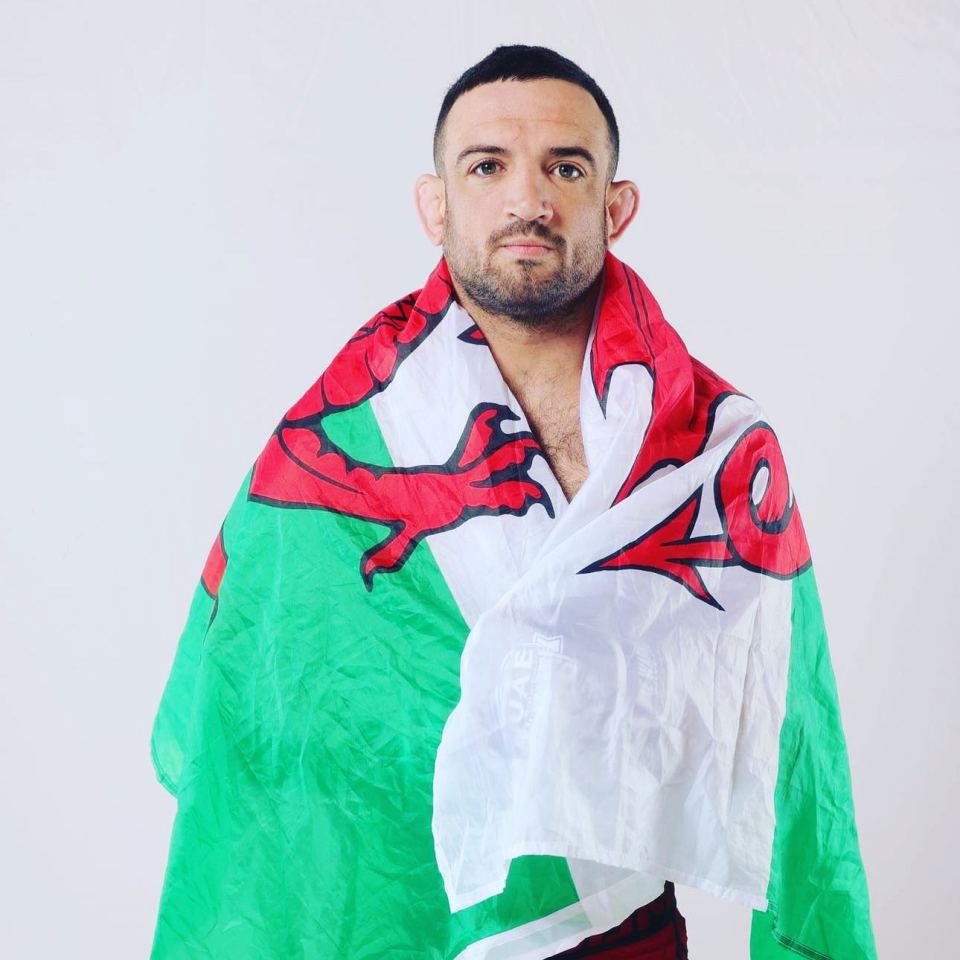 a man is wrapped in a green white and red flag with a dragon on it