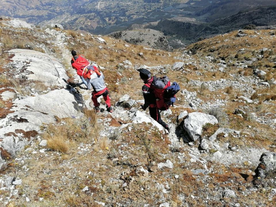 a group of people are hiking up a rocky hillside