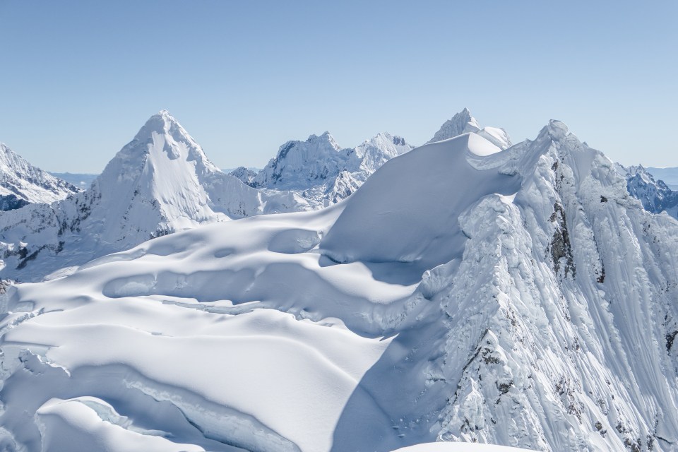 a snowy mountain with a blue sky in the background