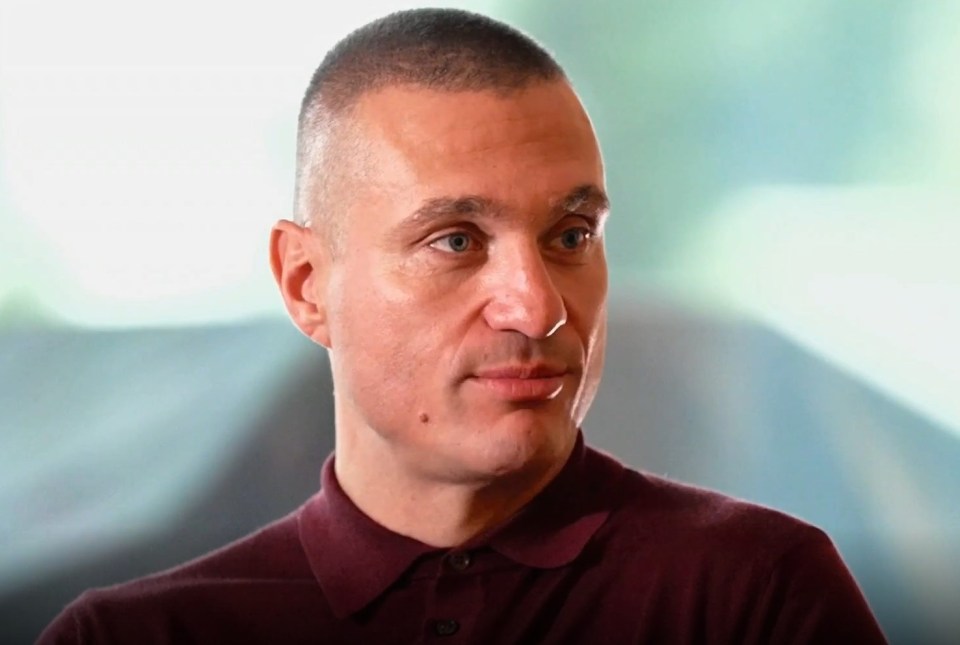 a close up of a man 's face with a red shirt on