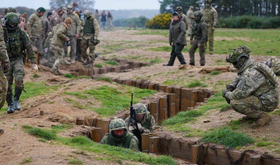 a group of soldiers are crawling out of a trench