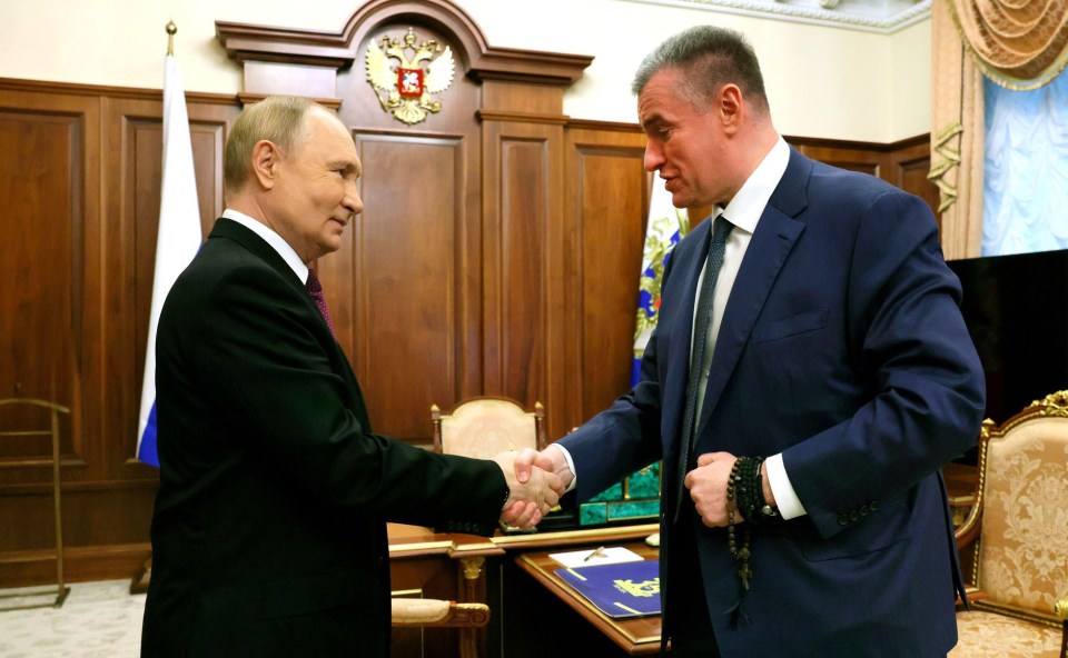 a man in a suit shakes hands with another man