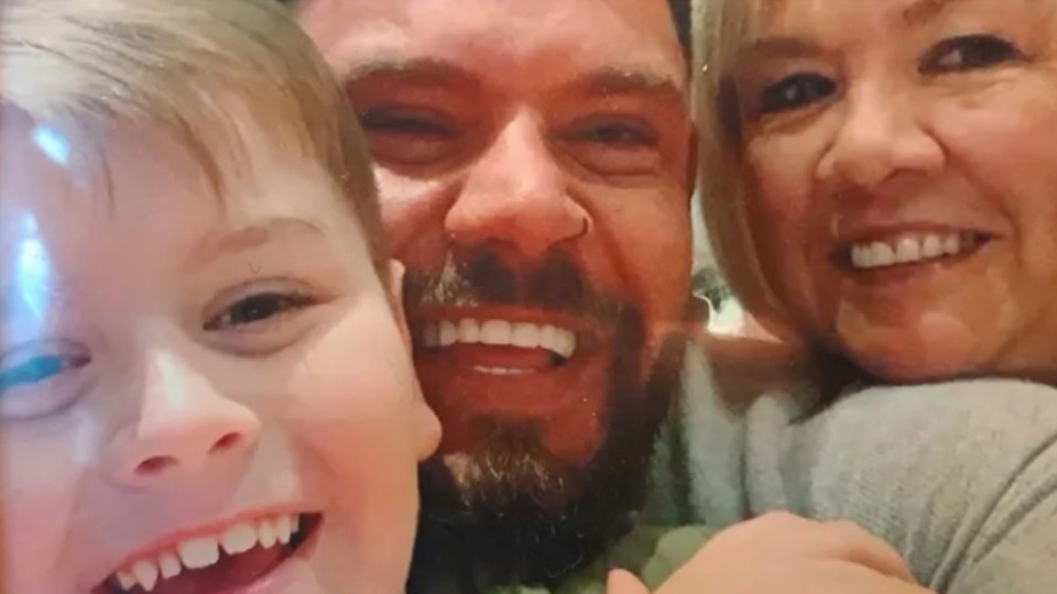 a man , woman and child are smiling for a picture .