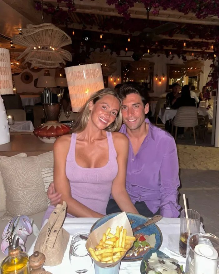 a man and a woman are sitting at a table with a plate of french fries