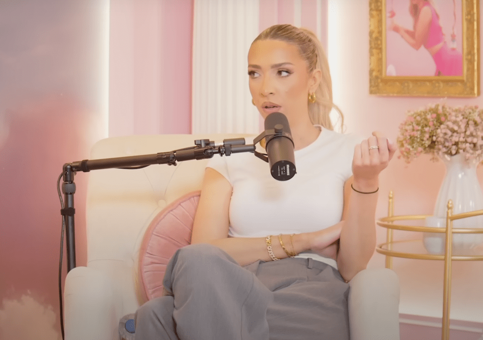 a woman sitting in front of a microphone with the letter l on it