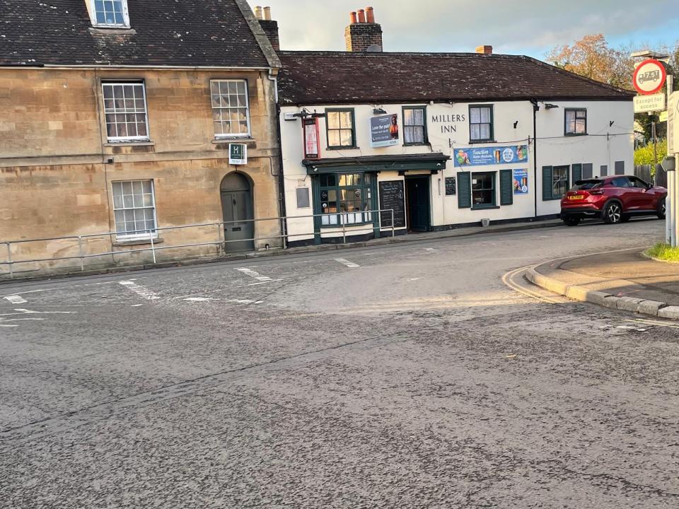 a red car is parked in front of millers inn
