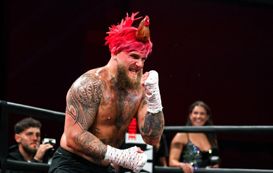 a man in a boxing ring has a rooster on his head