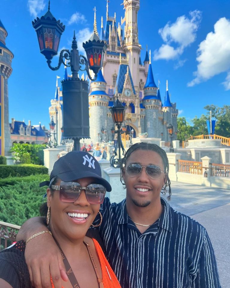 a woman wearing a ny hat stands next to a man wearing sunglasses