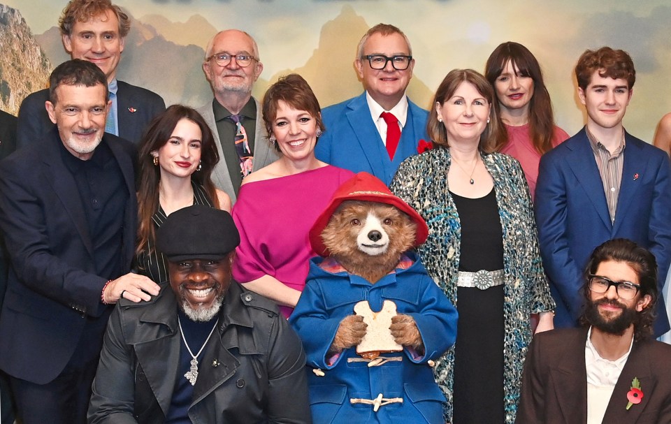 a group of people posing with paddington the bear