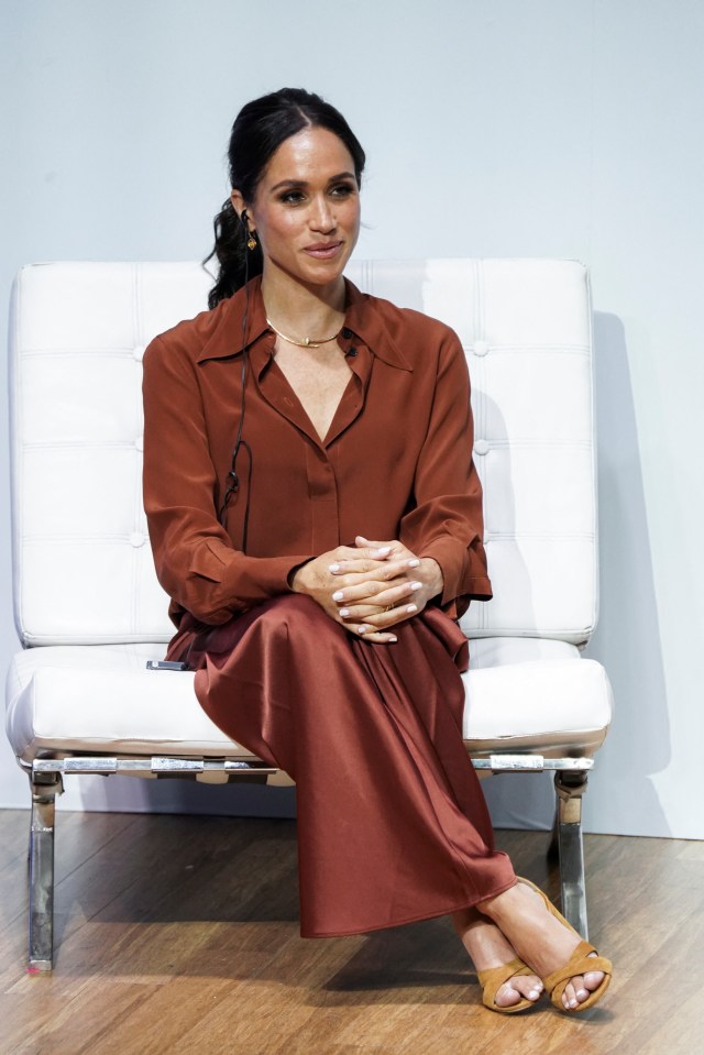 a woman in a red dress sits on a white chair