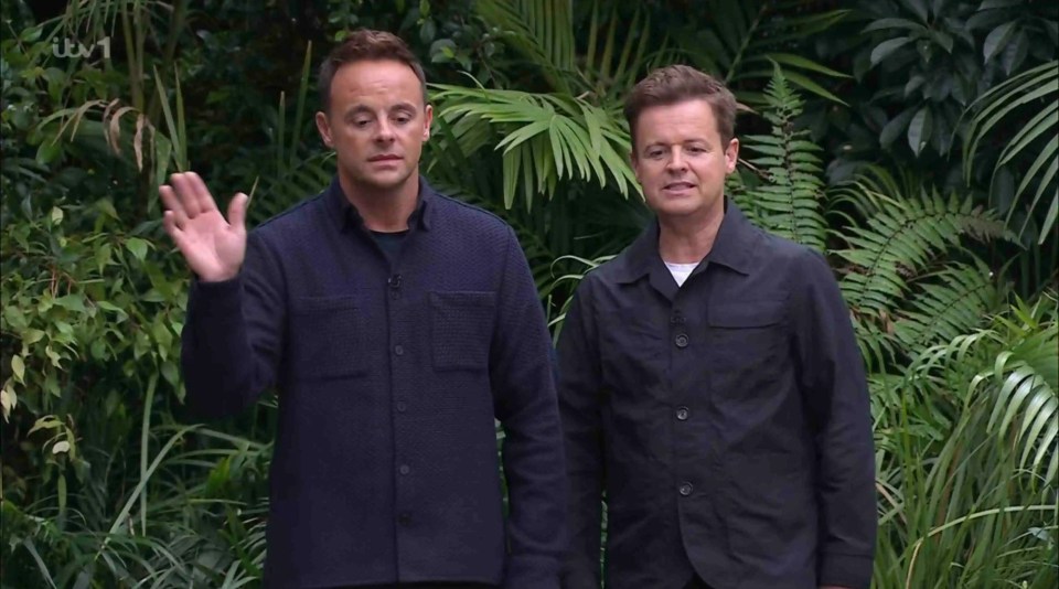 two men in black shirts are standing next to each other in the jungle