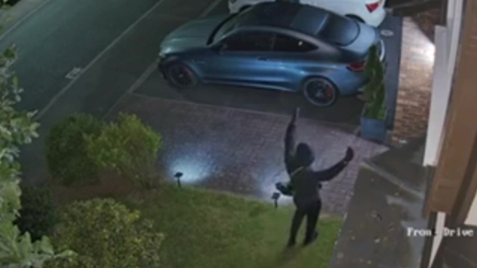 Nighttime security footage of a person stealing a car.