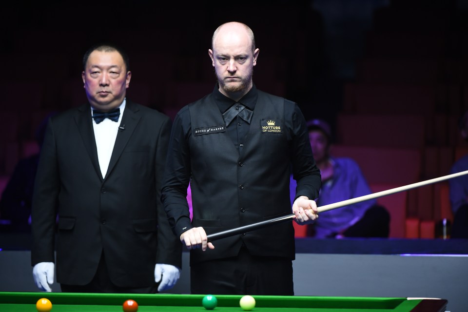 a man holding a pool cue with a shirt that says king of snooker on it