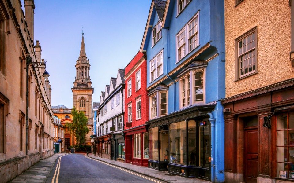 a row of buildings with one that has a sign that says ' for sale ' on it