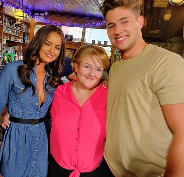 a man and two women are posing for a picture in a bar