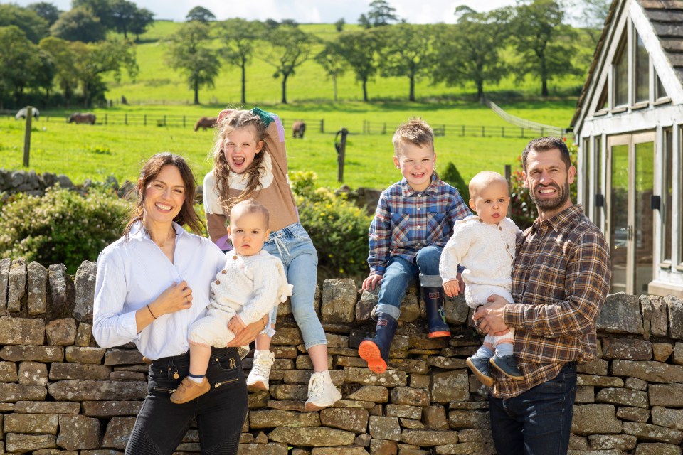 a family posing for a picture on a stone wall