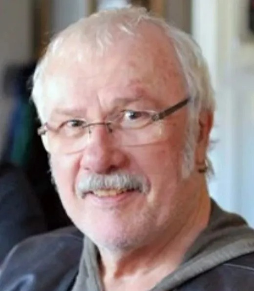 a man with glasses and a mustache is smiling for the camera