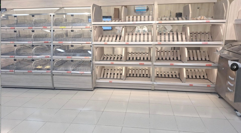 a row of empty shelves in a store with an arrow pointing to the right