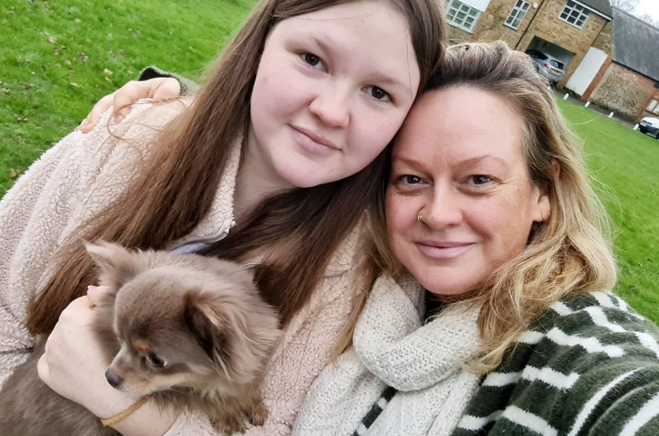 a woman and a girl holding a small dog